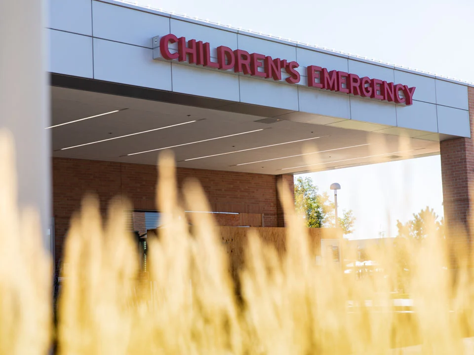 The entrance marquee for the Anschutz Emergency Department above a row of plants